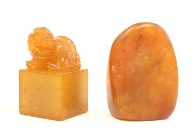 2 small Tianhuang seals: 1- Seal is surmounted by a finial in the shape of a recumbent dragon, uncarved seal surface approx. 1.6" H. 1- Pebble form seal, finely carved to depict a floral design in the front with a scholar on 