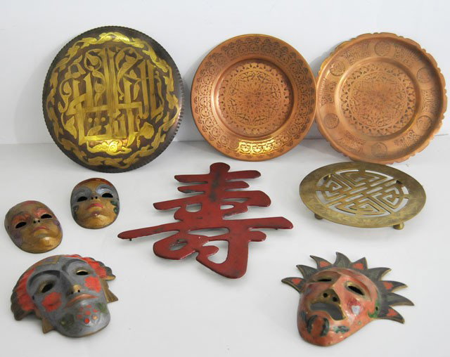 Group lot of assorted Asian smalls: 4- Brass painted masks, approx. 3" - 5" H. 1- Brass plate, approx. 8.75" Diam. 1- Brass plate, approx. 8" Diam. 1- Copper plate, approx. 8" Diam. 1- Red Chinese metal letter. 1- Trivet. From the estat