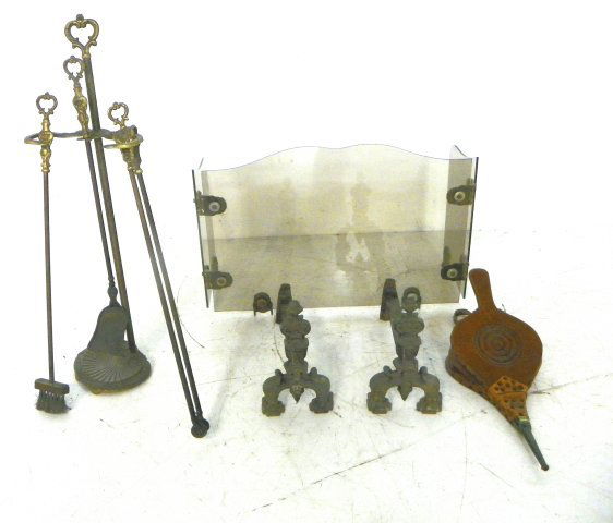 Group lot of fireplace items: 1- pair andiron. 1- Bronze mounted & tempered glass firescreen. 1- Set fire tools. 1- Bellows. Please read our terms of sale.
