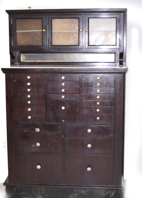 Mahogany dental cabinet: With crystal knobs & milk glass shelf. Approx. 39.5" x 64" H. From the estate of an Elizabeth, NJ Dentist.