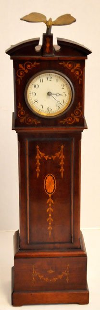 Sheraton miniature grandfather clock: Inlaid wood with "Floral" design with ''Butterfly" finials, satin inlays, key wind. Approx. 15.5" H. Partial contents of a North Plainfield, NJ mansion.