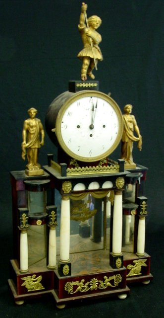 Early 19th c. French Empire clock: Wood with bronze mounts, mirrored back, "Chariot" pendulum, 6 marble columns adorned with wood figures. Approx. 13.5" W x 26" H. Partial contents of a North Plainfield, NJ mansion.