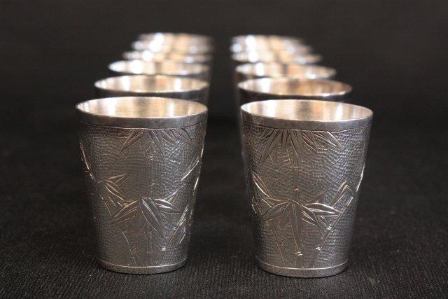 Set of 12 sterling silver shot glasses: Approx. 9 ozt, 279.4 g, 1.75 H. Marked Tackhing, made in Hong Kong.