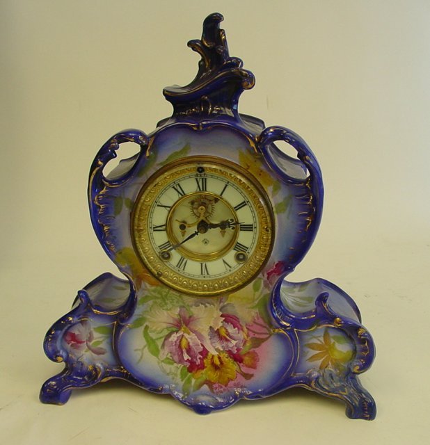 Porcelain case Ansonia clock: 19th - early 20th c. With open escapement. Lines on face. Royal Bonn case. WIth key & pendulum.