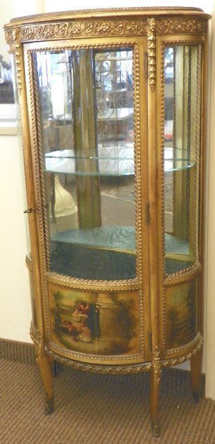 19th c. gilt wood Vernis Martin curio cabinet: Curved glass, mirrored back, glass shelf & fabric shelf, depicts courting scene on bottom, "Floral" design & "Portrait" applique. Approx. 27" x 13" x 55" H. Please read our terms of sale.