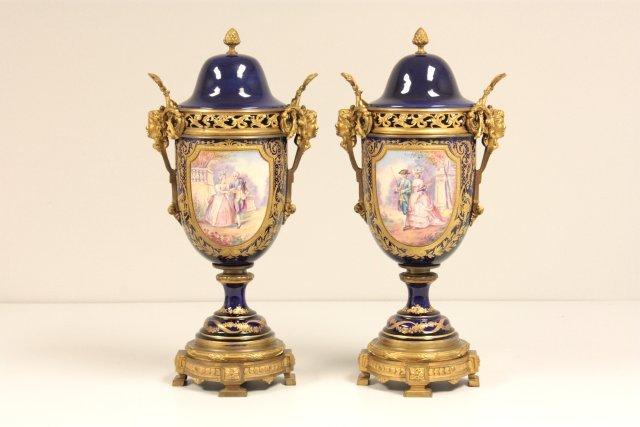 Pair cobalt porcelain hand painted Sevres urns: Fabulous quality, 19th c., depicting "A Stroll in the Park", covered, Victorian bronze "Head" mounts. Approx. 19.5" H. Please read our terms of sale.