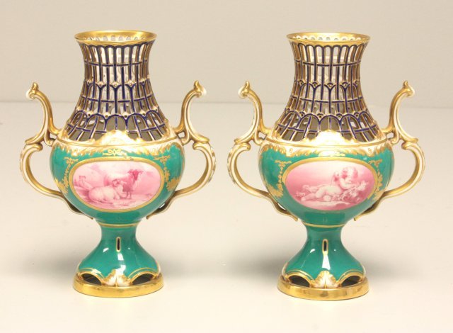 19th c. matched pair Minton porcelain vases: Hand painted in green, gilt & cobalt, reticulated ., 1 is unsigned, both have 2 panels, depicts "Cherubs" & "Lambs". Approx. 8.25" H. Please read our terms of sale.