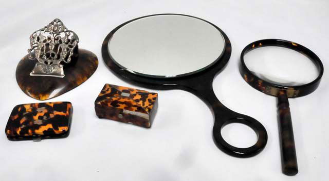 Group lot of 5 tortoise shell items: 1-Tortoise shell match safe with design on cover depicting "2 Boxers", approx. 2.75" x 2". 1- Tortoise shell & silverplate paper holder. 1- Tortoise magnifying glass. 1- Hand mirror in tortoise shell