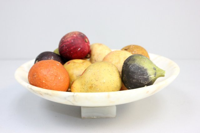 19th c. Italian alabaster compote & fruit: Including: 1 apple, 1 pear, 3 figs, 2 peaches, 1 tangerine, 1 unknown fruit. Old repair to compote. 11 pieces in total. Compote approx. 3.5" H x 11" Diam. Please read our terms of sale.