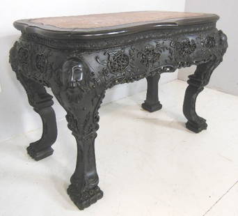 Carved Chinese teakwood table: With rouge marble inset, carved "Heads" on each corner. Approx. 45" W x32" H x 25" D. Consigned from a NJ gentleman. Please read our terms of sale.