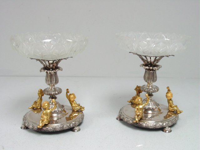 Pair Sheffield signed silverplated centerpieces: With glass liners & figural "Cupid" decorations. Approx. 10.75" H x 9" W.