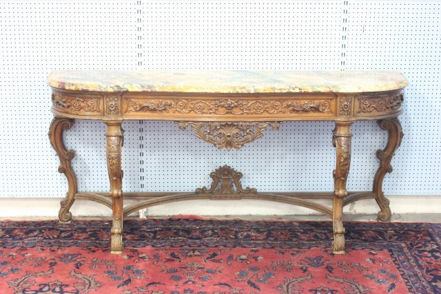 French style marble top heavily carved sideboard: Early 20thc. heavily floral carved sideboard with magnificent marble top in tones of gold, rouge, verde and black. Sideboard has 1 carved center drawer with 2 carved pulls and 2 carved corner pullout 