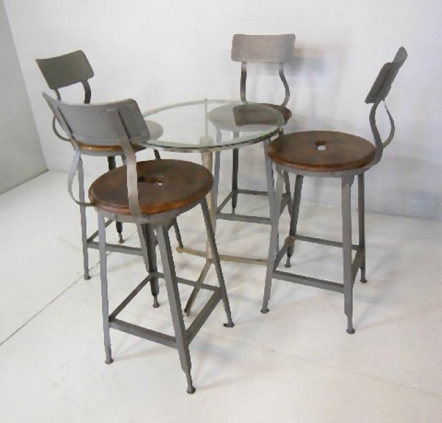 Glass top metal table with 4 industrial bar stools: Round glass top metal table and 4 Industrial bar stools.