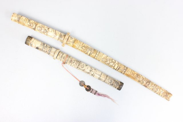 2 carved Chinese bone swords: Large sword as is, depicts "Figures". Large approx. 28.25", small 16.5". From a Middletown, NJ collection.