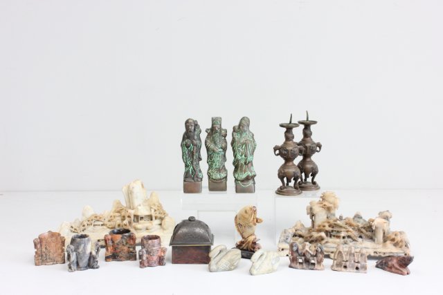 18 pieces of Orientalia: Including: 2- Soapstone carvings depicting "Landscapes", approx. 10" W x 6" H. 1- Pair bronze candlesticks, approx. 6.75" H. 6- Bronze "Immortals", approx. 6" H. 2- Groups of "Monkeys"- "See no evil, 