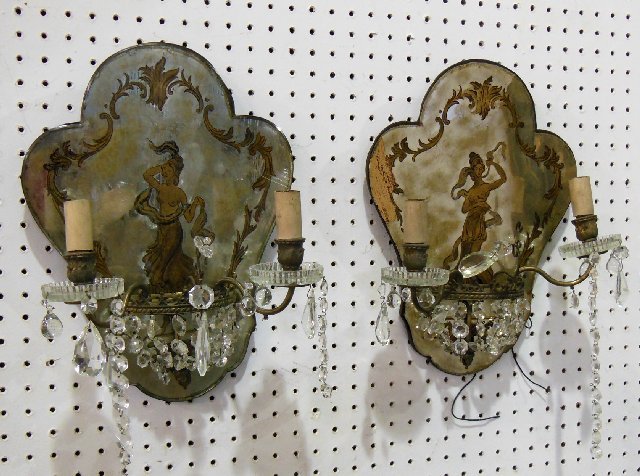 Pair eglomese mirrored 2 arm sconces: With hanging crystals, bronze mounts, gold reverse painting, depicts "2 Semi-clad Nymphs", electrified. Paint lose and glass missing on one sconce. Approx. 15" x 12" x 7" D.