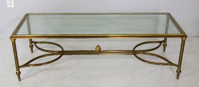 Brass & glass rectangular coffee table: With trestle base with beading. Arpprox. 50" W x 20" D x 15.5" H.