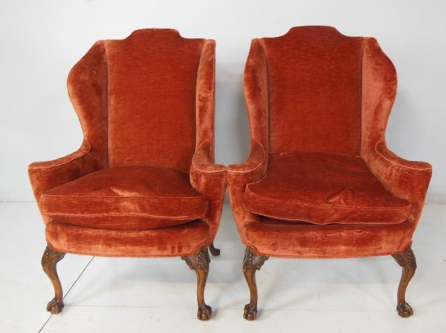 Pair red upholstered wingback chairs: With ball & claw feet. Approx. 45" H x 32" arm to arm.