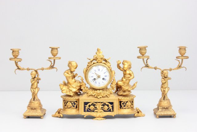 3 piece 19th c. dore bronze clock set: French with handpainted porcelain plaques stamped Girard, stamped on face Raingo Pres. A. Paris. 1 cherub missing something out of his hand. No pendulum. Approx. 11" H x 14" across, candelabra 11" H.