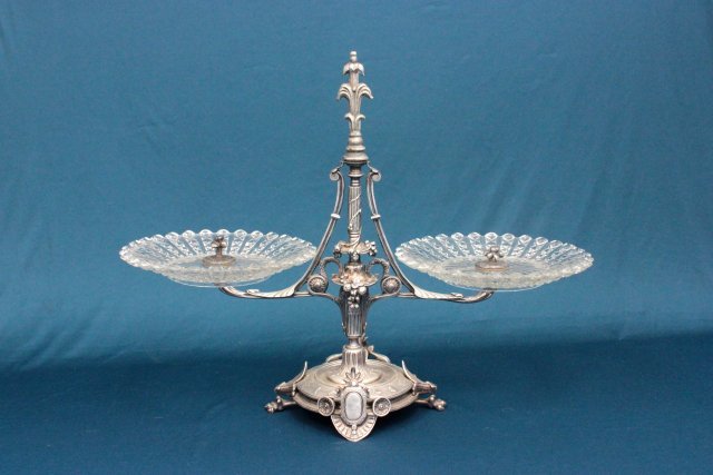 Aesthetic movement silver plated bronze epergne: 19thc. with 2 glass dishes. Finial not original. Approx. 16" H. 20.5" W.