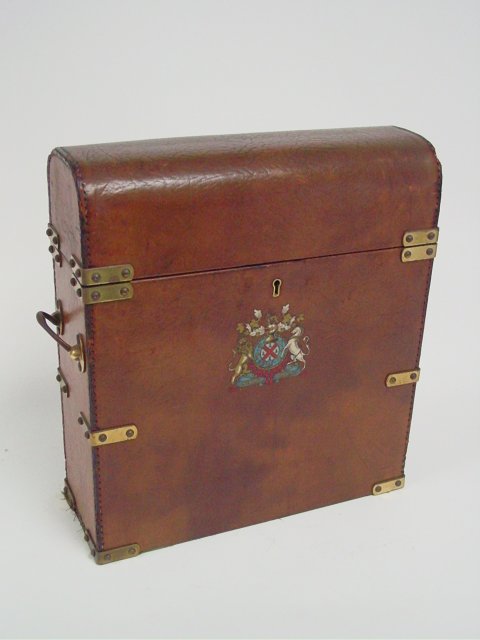 Tooled leather liquor box with domed top: Drop lid with lock, emblem on front depicts "English Crown", with brass straps. Mid century original.