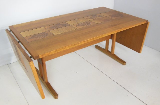 Danish modern drop leaf table: With chip on leaf, "Pine Tree" design, stamped Denmark. Approx. 63.5" x 36" W x 28.5" H, leaf approx. 19.25" x 36".