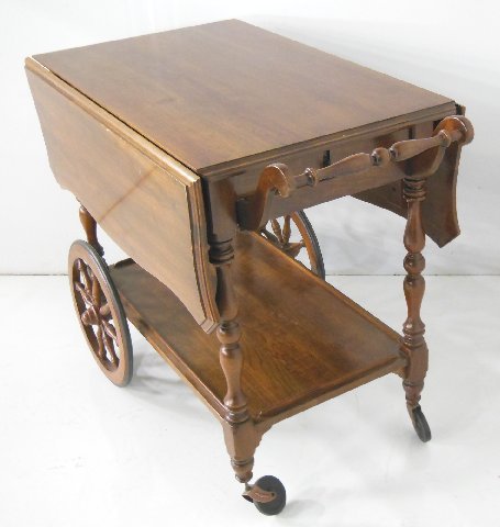 "Kling" cherry mahogany tea cart: 1 drawer. Approx. 29.5" H x 37" x 20" W (closed), 41" (open).