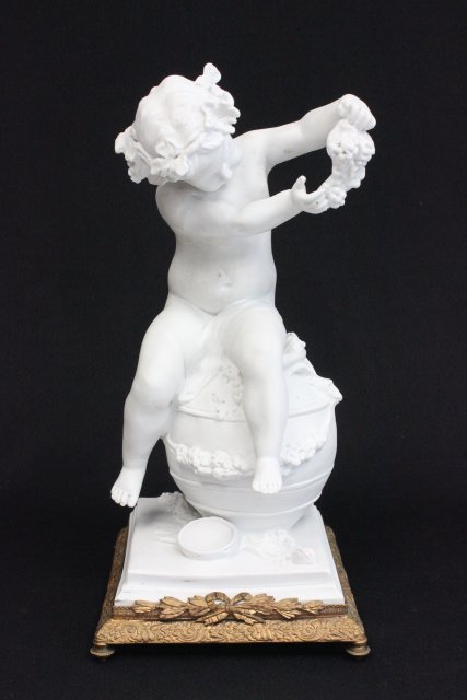 Sevres Parian figure: Depicting "Child with grapes& leaf wreath sitting on wine barrell". Clodion, France on base. Approx. 14.5" H x 7" W x 7" D.