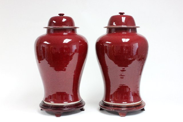 Pair Chinese large red porcelain ginger jars: On wooden stands, lidded. Approx. 24" H.