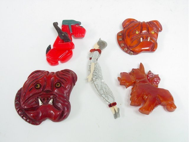 Lea Stein pin & 4 Bakelite 1950's "Dogs": 1- "Lady Diver" pin by French designer Lea Stein, made of laminated cellulose acetate, signed, approx. 5" L. 1- 1950's Bakelite "Scottie Dog" brooch, approx. 3" x 3". 1- "Scottie Dog holding a Rifle",