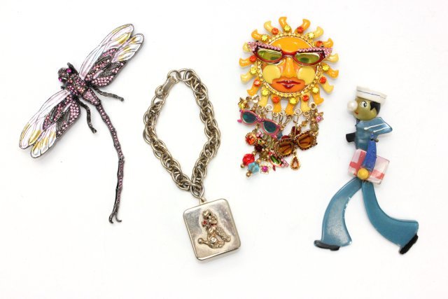 Lot of 3 costume pins & bracelet: Including 1- LATR260 pin depicts a "Sun Wearing Sunglasses", approx. 4" x 2.75". 1- "Dragonfly" pin with colored rhinestones, approx. 4.25" x 4". 1- 1930's "Sailor" pin with moveable legs, approx. 4.2