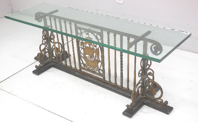 Glass top iron coffee table: "Scene of Ship" in the manner of Oscar Bach, ca. 1920's. Approx. 48" x 16" x 20".