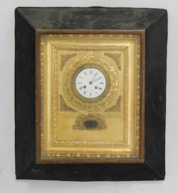 German Neo-Classic style giltwood wall clock: From the Estate of Chris Peckham. In black baize surround. Approx. 24.25" H x 21" W. Outer frame worn. Slight cracking on face. 1 hinge loose.