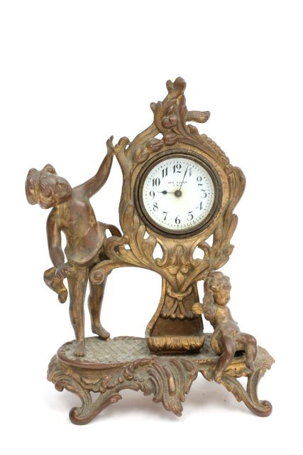 Small brass finish figural New Haven clock: With "Putti". Approx. 9" H x 6.5".