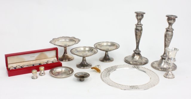 Lot of sterling silver: Including: 3 weighted compotes, 8 Cartier salt & peppers, Pair weighted candlesticks, cups, picture frame as is. Weight indeterminate.
