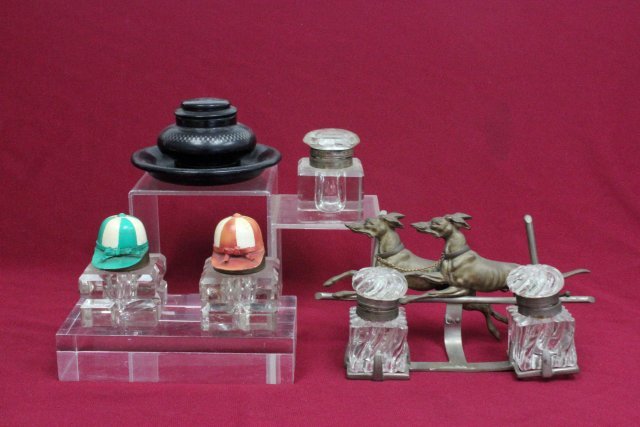 Group of inkwells: Including: 1- metal "running dog" in stand approx. 4" H x 8" W; Pair of wells with painted metal jockey jar lids approx. 3 x 2; 1- Papier mache with Milo work approx. 2.75" H x 4.25" diam; and 1- crys