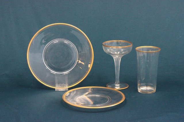 Gilt decorated glass partial service set: Including dinner plates, dessert plates, champagne glasses, and other glasses. Approx. 40 pieces. Some wear to gilding. From the estate of Chris Peckham.