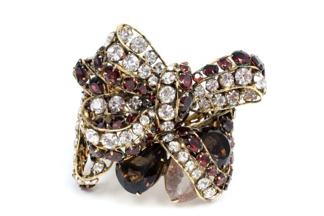 C & D Jewelry bow bracelet: Bow design hinged bracelet made from brass and set with topaz, citrine, garnet, rutilated quartz and crystal stones. Approx. 2 1/2" wide in front and has a 6 1/4" interior. From the estate of Anita St