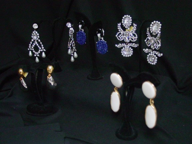 Kenneth Lane costume earrings: Approx. 5 sets including 1 pair of rhinestone and pearl chandelier earrings with faceted emerald and round cut rhinestones. Early mark. Clip ons. Approx. 4" drop. 1 pair of Asian inspired blue floral 