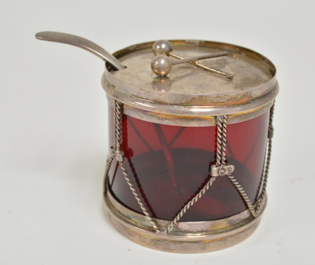 Sterling silver and ruby glass honey jar: With spoon. Shaped like a drum and sticks, 3" x 3" From the estate of Chris Peckham.