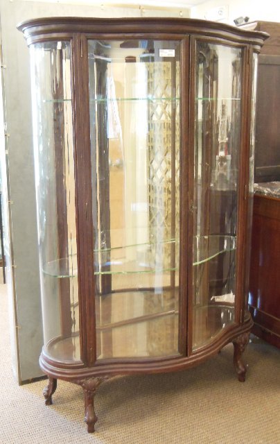 Monumental late Victorian oak China cabinet: Serpentine double glass front door, bowed out glass sides, mirrored back, glass shelves, cabriole legs, all glass has beveled edges. Approx. 70" H x 18" D x 48" across. (3468.9)