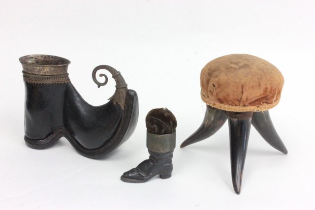 Victorian horn pin cushion & metal shoe: Victorian horn pin cushion 5 1/2"H modelled as a stool together with a metal boot form pin cushion and a metal mounted shoe. Fabric worn, scratches. From the estate of Chris Peckham