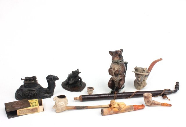 Group of 8 smoking related items: Including: rare camel lighter, frog lighter missing top; German porcelain bear pipe; meerschaum cigarette holder, carved reclining angel, Victorian woman's head pipe (worn), snail shaped pipe and pipe