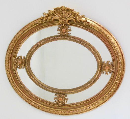 Large oval gilded mirror: Wear to gilding. 48 W x 45 H
