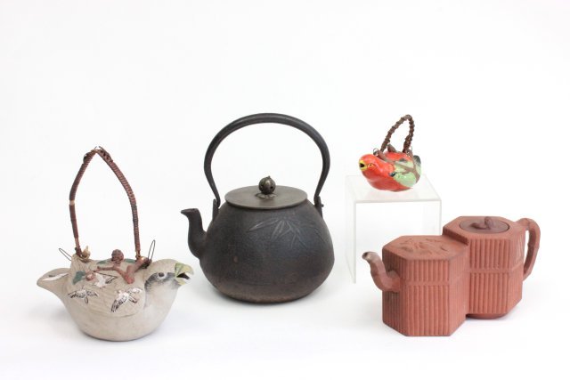 Group of 4 Oriental tea pots: Including 2 bird form, 1 cast iron with bronze lid and a ceramic pot. The largest 8 1/2" H. 3 signed. Condition: handlles worn on bird pots, oxidation, minor chips. (From the Estate of Chris Peckham)