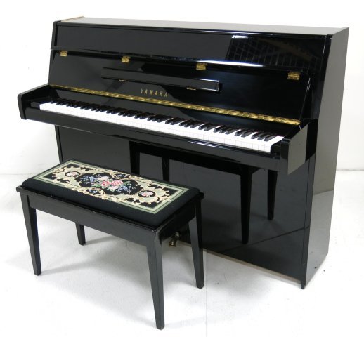 Yamaha T129570 upright piano: Black lacquer. With bench, needle point seat. Approx. 43" x 58" W x 22" D.