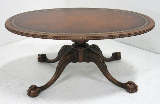 Leather top claw foot coffee table: Brown gold tooled, center pedestal base. Ca. 1930's. Approx. 28" x 40" x 17" H. Good condition.
