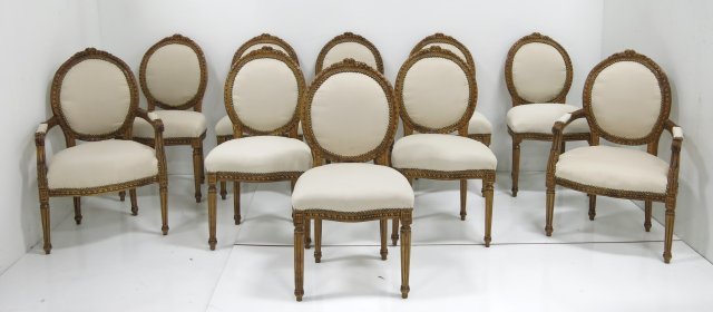 10 Louis XVI style French dining room chairs: Beige fabric. Beech wood. 2 arm chairs & 8 side chairs. Approx. 40.5" H, seat back 21" H, seat from ground 22" H, seat 22.5" W x 17.5" D.
