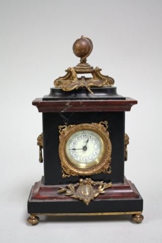 Louis XVI style porphyry, marble & ormolu clock: Globe motif on crest. 19th century. Approx. 10" x 6" x 2.5" D. From the estate of John Sciortino.