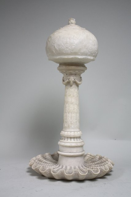 Alabaster carved figural lamp: Wreath design and ram's head; winged faces on shade, 29 1/2"H. Minor flakes